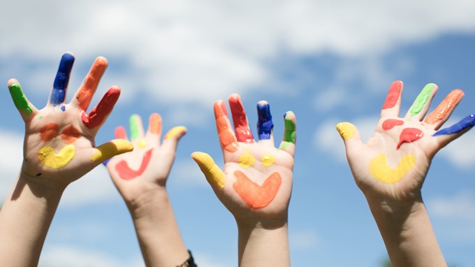 Barnhänder som är målade i olika färger