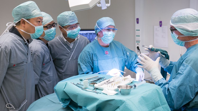 I de kinesiska tandläkarnas fortbildning i Jönköping ingår bland annat observation av operationer på käkkirurgiska kliniken. Käkkirurgen och klinikchefen Peter Nilsson förklarar steg för steg när han tillsammans med tandsköterska Anna Stanton utför operation av ett tandimplantat. 