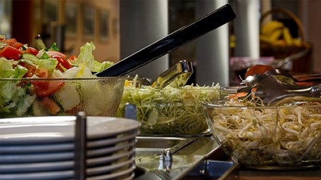 Salladsbuffé i skolans matsal med glasskålar fyllda av sallad och grönsaker.