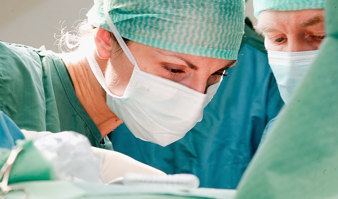 Läkare utför operation, närbild på läkarna