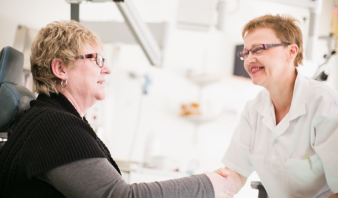 Läkare och patient hälsar på varandra