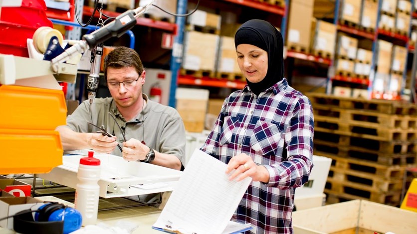 En man och en kvinna på en industri arbetar tillsammans. 