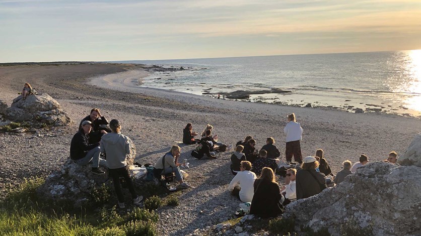 En grupp människor i solnedgången på en strand