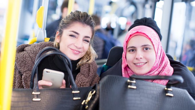 Två kvinnor åker buss. 