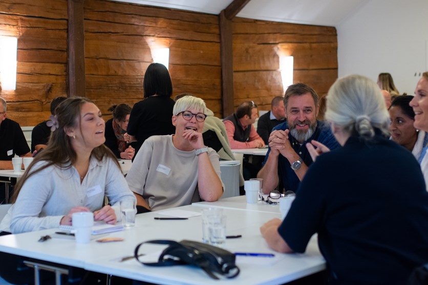 Eventdeltagare sitter runt ett bord och diskuterar.