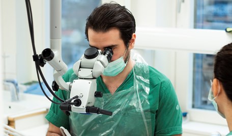 En man tittar i mikroskop