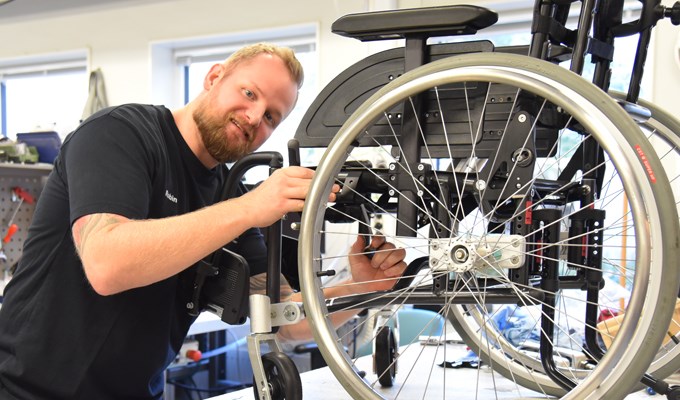 En hjälpmedelstekniker utför service på en rullstol.