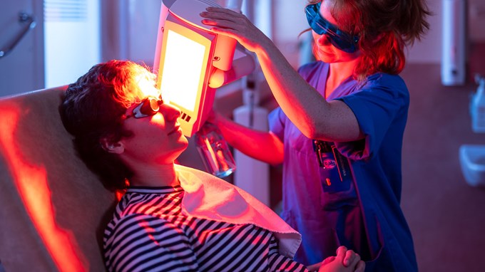 En medarbetare på hudkliniken behandlar en patient.