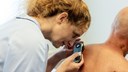 En läkare på hudmottagningen i Jönköping undersöker huden på en patient.
