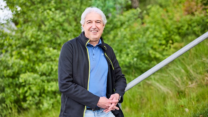 En person står i en trappa utomhus och ler mot kameran. 