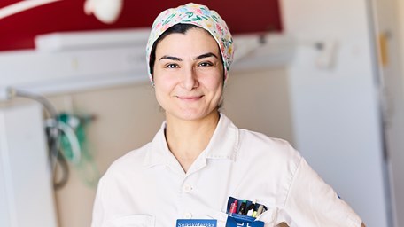 Sjuksköterska i arbetskläder som ler. 