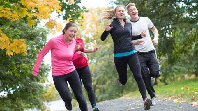 Fyra personer motionsspringer, de är klädda i färgglada kläder och ser glada ut. 