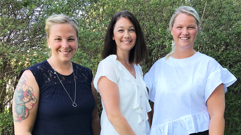 Tre sjuksköterskor, Elin Strömstedt, Alexandra Sandberg och Emma Tingvall, står framför ett buskage. 