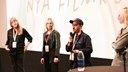 Fyra personer samtalar på scen i en biosalong.