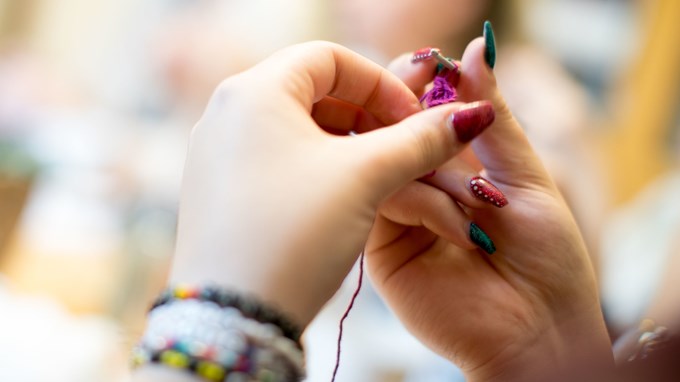 Händer som slöjdar.