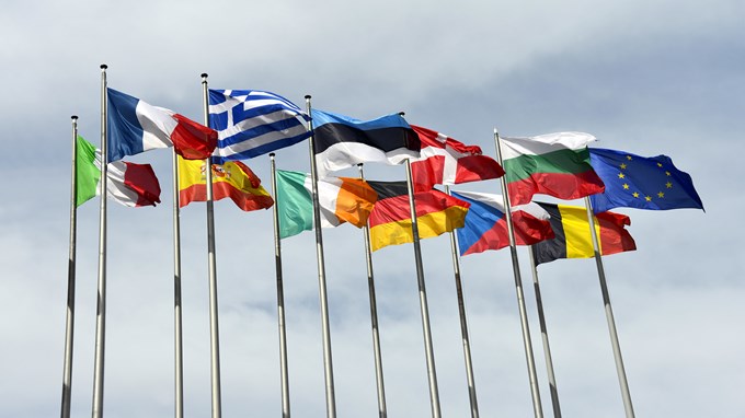 Flaggstänger med olika europeiska flaggor som vajar i vinden. 
