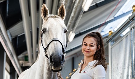 En elev tränar på att linda hästens ben tillsammans med en lärare.