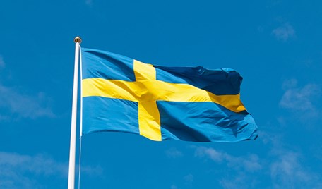 Svensk flagga som vajar i vinden.