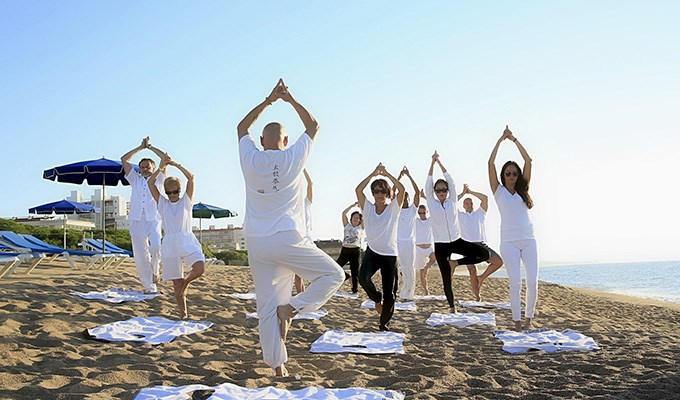 personer som tränar yoga på strand